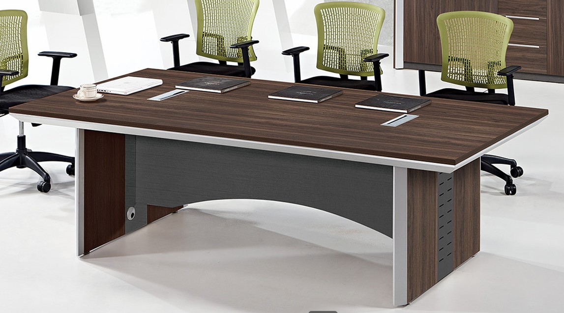 Dark walnut conference table with green mesh chairs in a corporate meeting room